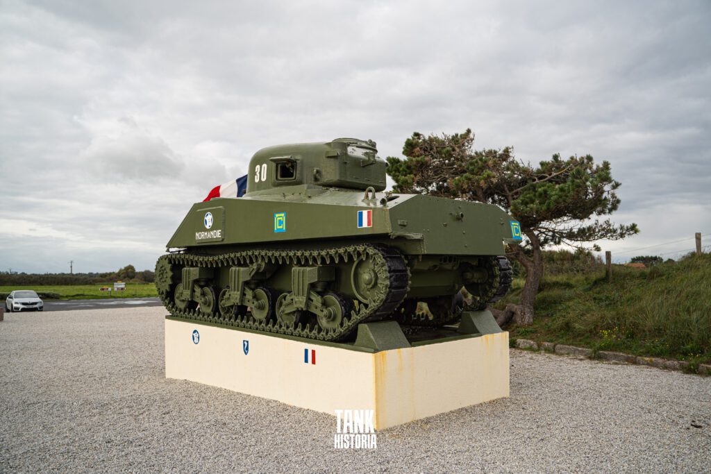 Car parking in front of the tank.